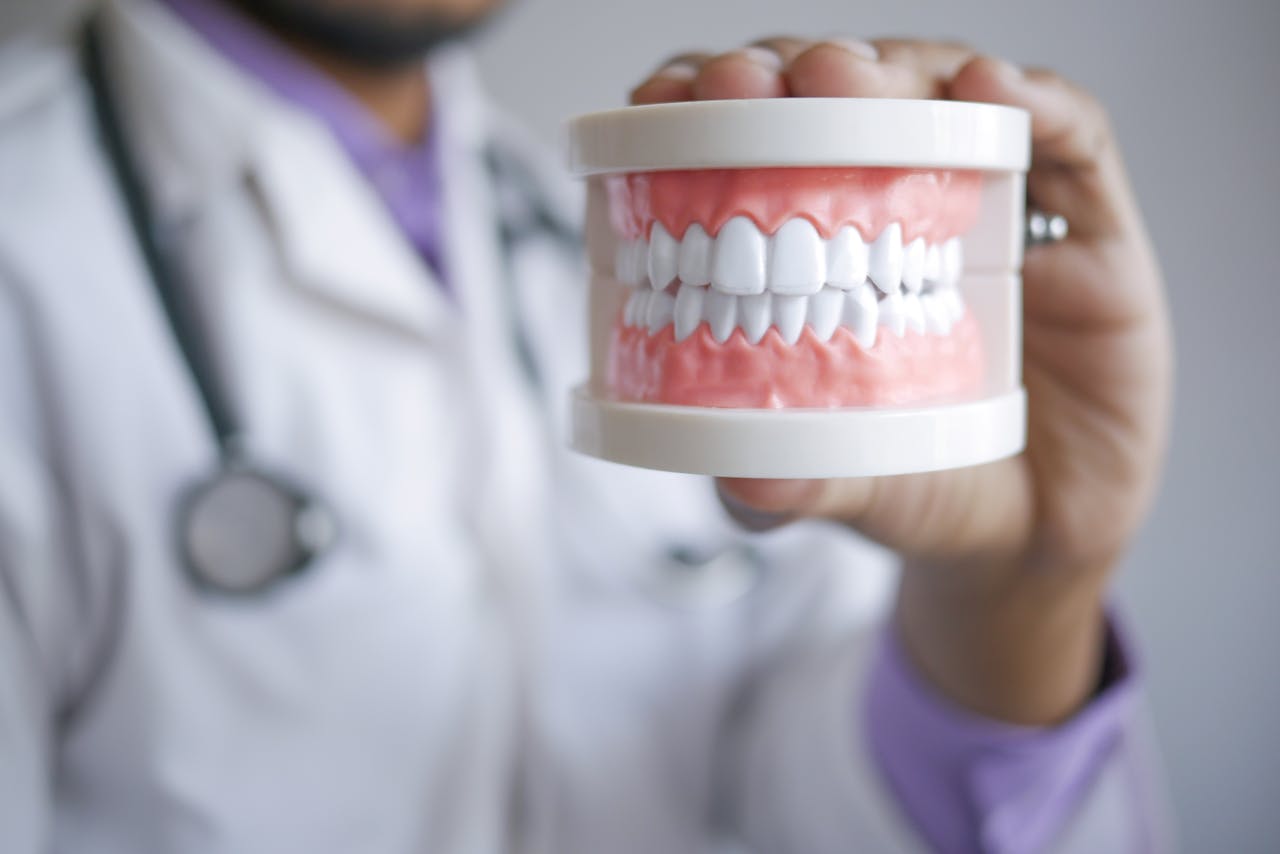 services-03 Closeup of a dentist holding a dental prosthetic in a clinical setting, emphasizing prosthodontic care.
